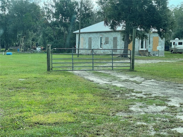 view of gate with a yard