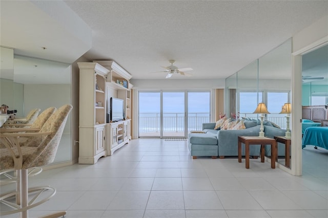 tiled living room with ceiling fan and a textured ceiling