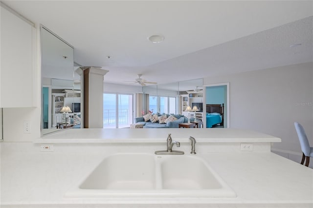 kitchen with kitchen peninsula, ceiling fan, and sink