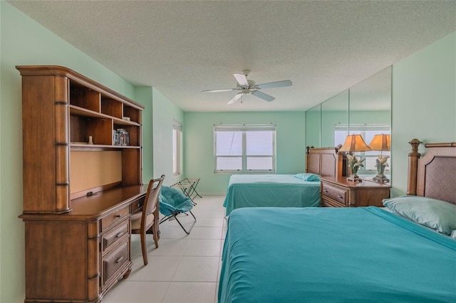 bedroom featuring light tile patterned floors, a textured ceiling, and ceiling fan