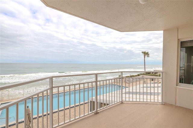 balcony featuring a water view and a beach view