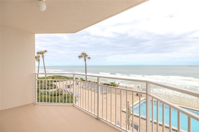 balcony featuring a view of the beach and a water view