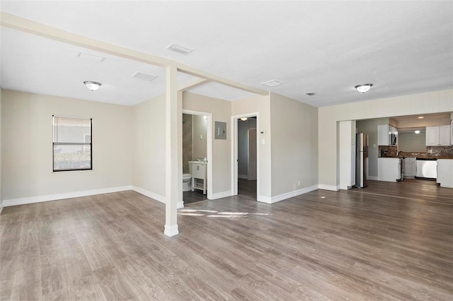 unfurnished living room with hardwood / wood-style flooring and electric panel