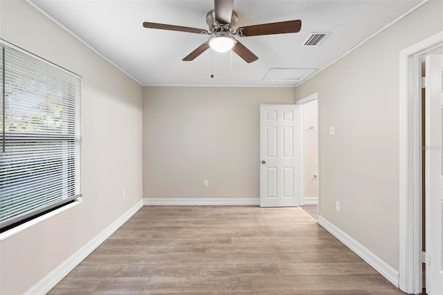 spare room with ceiling fan, light wood-type flooring, and ornamental molding