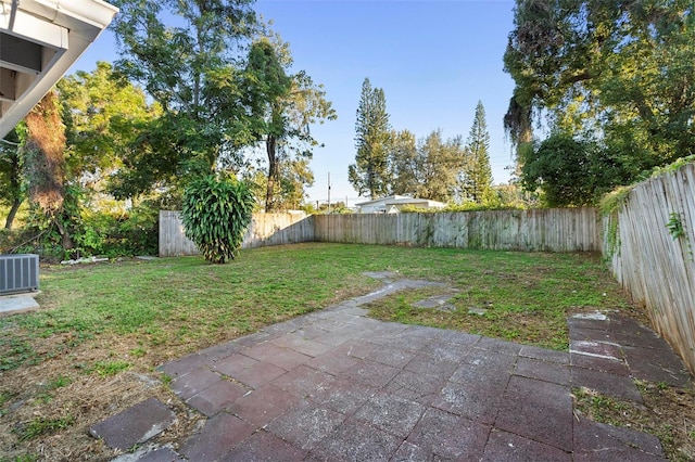 view of yard with central air condition unit and a patio area