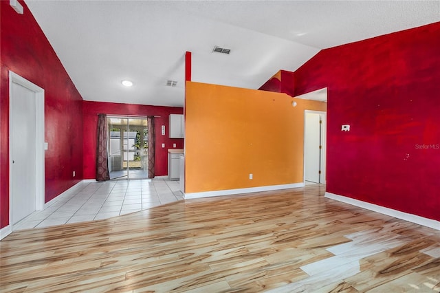 foyer entrance featuring light wood-type flooring and high vaulted ceiling