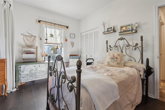 bedroom with dark wood-type flooring and a closet