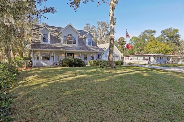 cape cod house featuring a front yard and a porch