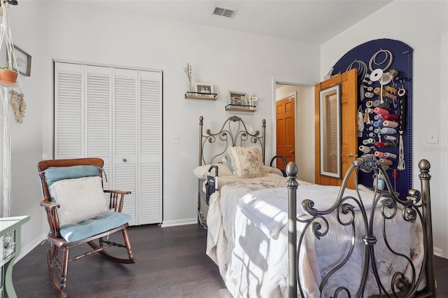 bedroom with dark hardwood / wood-style floors and a closet