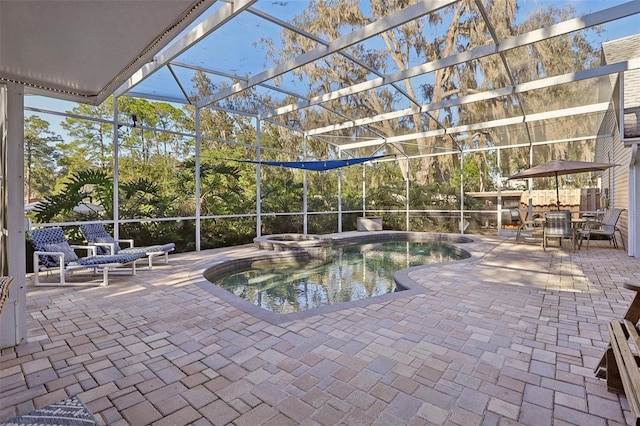 view of pool with a lanai, an in ground hot tub, and a patio