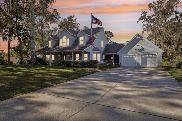 cape cod home featuring a yard, a porch, and a garage