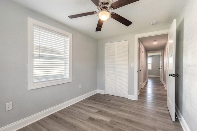 unfurnished bedroom with ceiling fan, light hardwood / wood-style flooring, and a closet