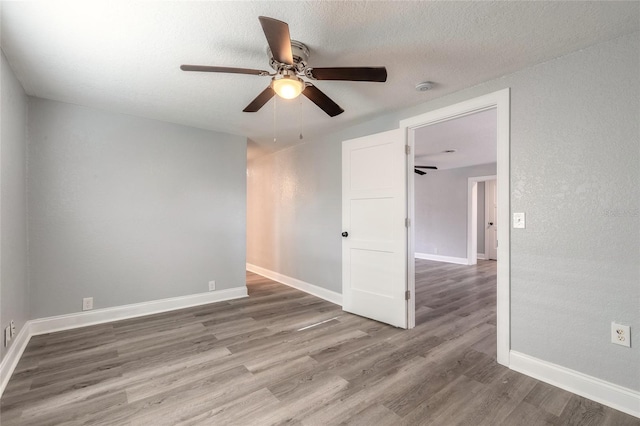 spare room featuring wood-type flooring, a textured ceiling, and ceiling fan