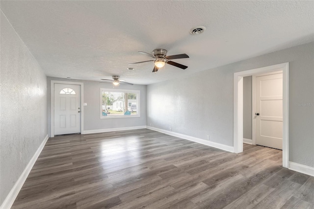 interior space with wood-type flooring, a textured ceiling, and ceiling fan