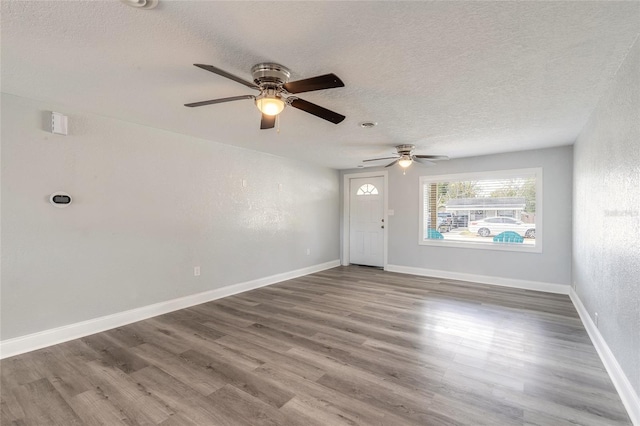 interior space with ceiling fan, wood-type flooring, and a textured ceiling