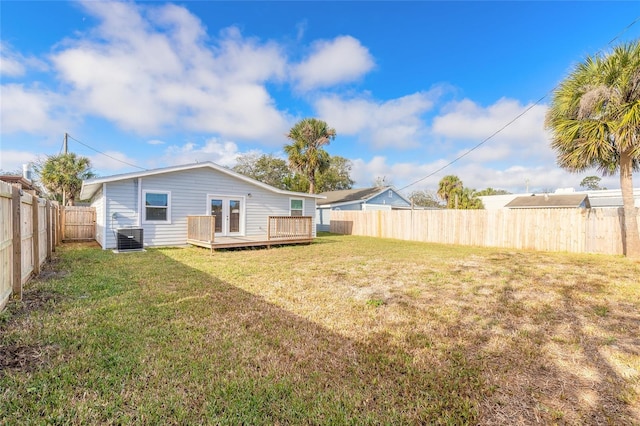 back of property with central AC, a yard, and a deck