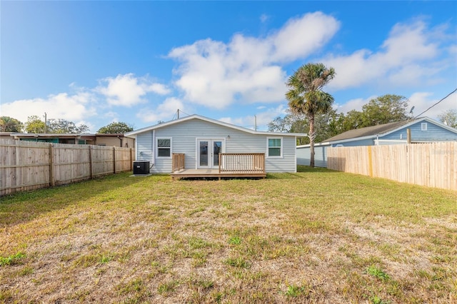 back of property with french doors, a deck, a yard, and central AC