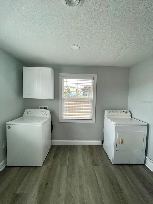 clothes washing area with cabinets, hardwood / wood-style floors, a textured ceiling, and separate washer and dryer