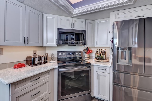 kitchen with white cabinets, a textured ceiling, stainless steel appliances, and light stone counters