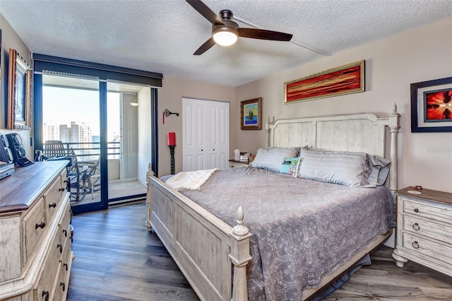 bedroom featuring a textured ceiling, a closet, dark wood-type flooring, and ceiling fan