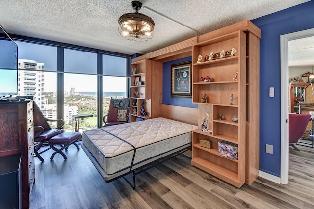 bedroom with wood-type flooring and a textured ceiling