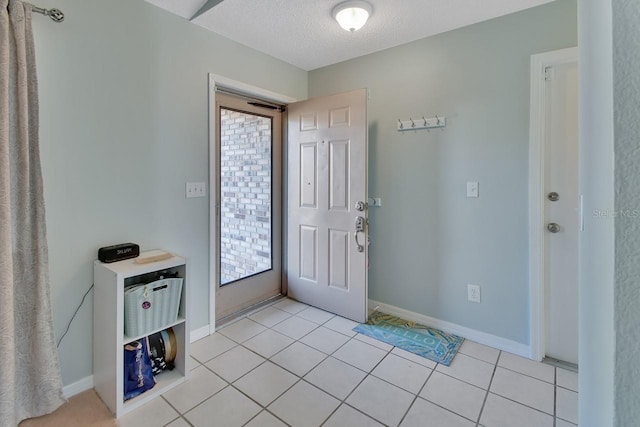 entryway with light tile patterned floors and a textured ceiling