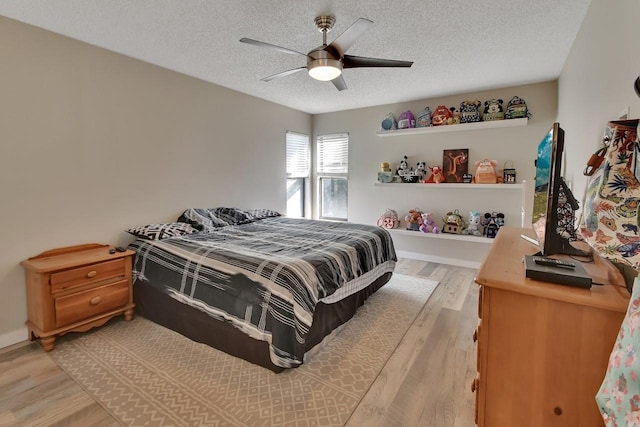 bedroom featuring a textured ceiling, light wood-type flooring, and ceiling fan