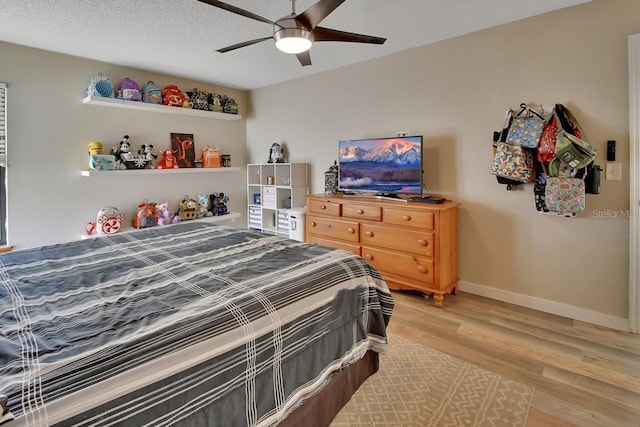 bedroom with ceiling fan, a textured ceiling, and hardwood / wood-style flooring