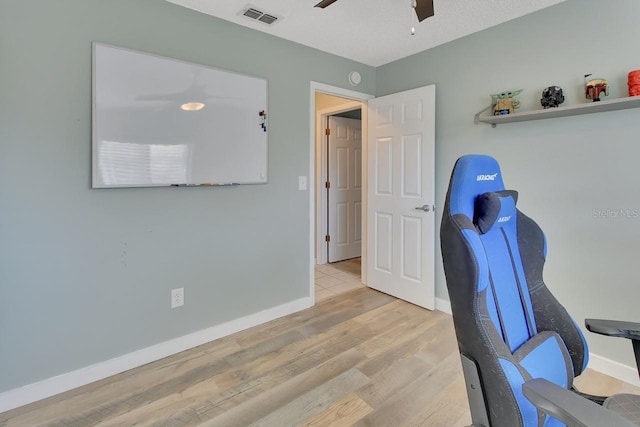 office space with ceiling fan, light wood-type flooring, and a textured ceiling