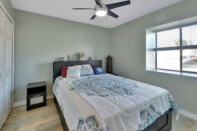 bedroom featuring ceiling fan, a closet, and light wood-type flooring