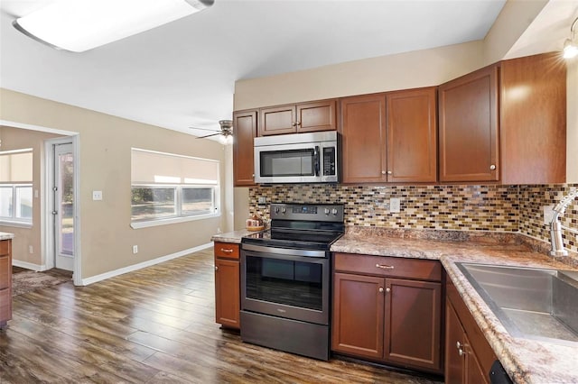 kitchen with appliances with stainless steel finishes, dark hardwood / wood-style floors, tasteful backsplash, and sink