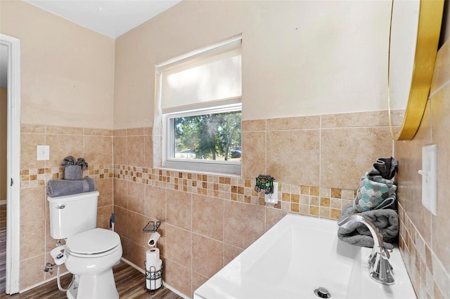 bathroom with sink, toilet, tile walls, and hardwood / wood-style flooring