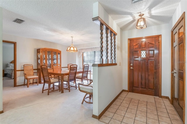 entryway featuring a chandelier, light colored carpet, and a textured ceiling