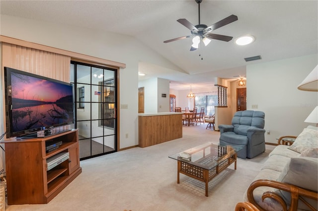 carpeted living room with ceiling fan and lofted ceiling