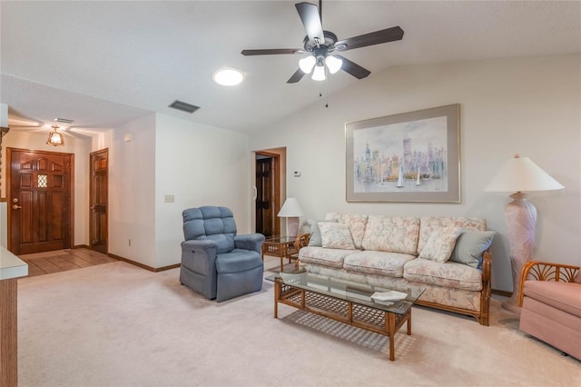 carpeted living room with ceiling fan and vaulted ceiling