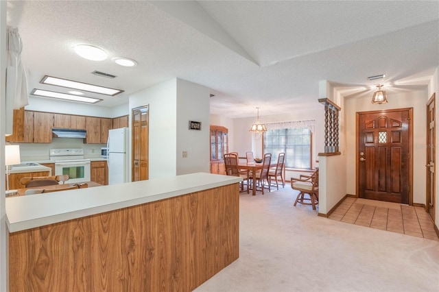 kitchen with light carpet, a textured ceiling, white appliances, and decorative light fixtures