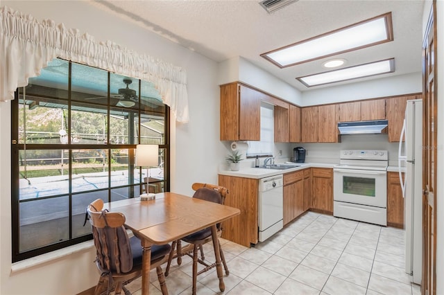 kitchen featuring ceiling fan, sink, a textured ceiling, white appliances, and light tile patterned flooring