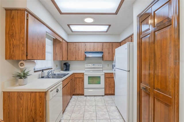 kitchen with light tile patterned flooring, white appliances, and sink