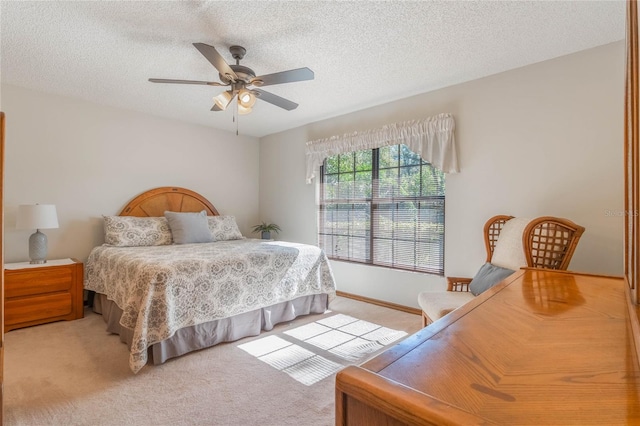 bedroom featuring a textured ceiling, ceiling fan, and light carpet