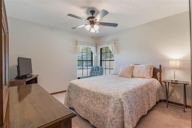 carpeted bedroom featuring ceiling fan and a textured ceiling