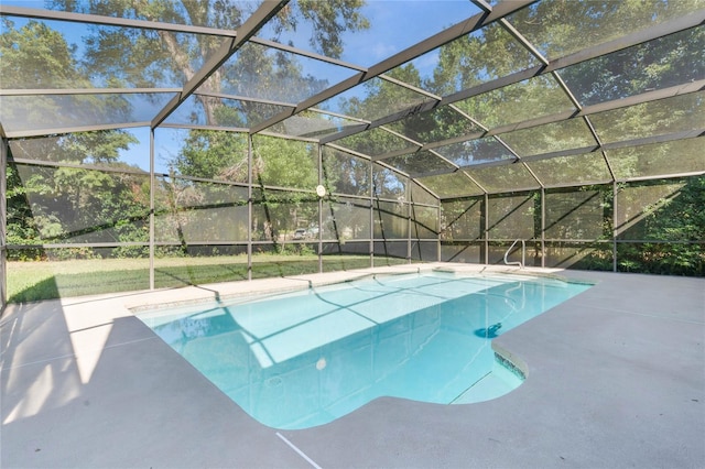 view of pool with glass enclosure and a patio area