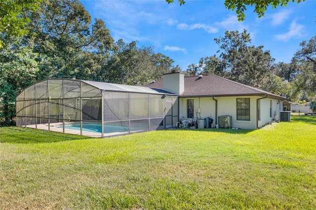 back of property featuring a lanai, central AC, and a lawn