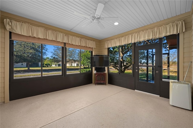 unfurnished sunroom with ceiling fan