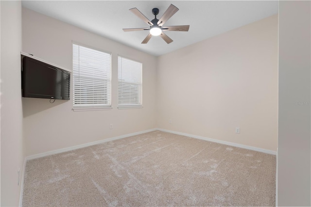 empty room featuring ceiling fan and light colored carpet