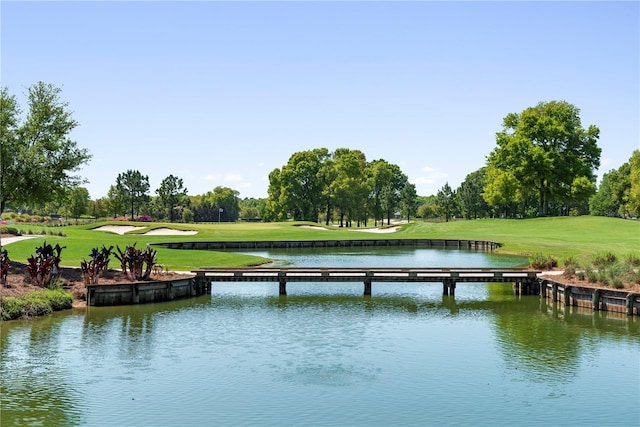 view of dock with a water view and a lawn