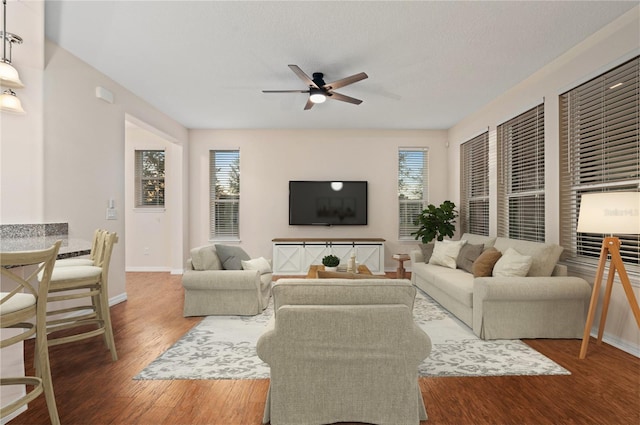 living room featuring hardwood / wood-style flooring, ceiling fan, and a wealth of natural light