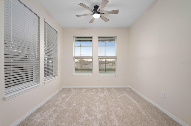 spare room with ceiling fan and light carpet