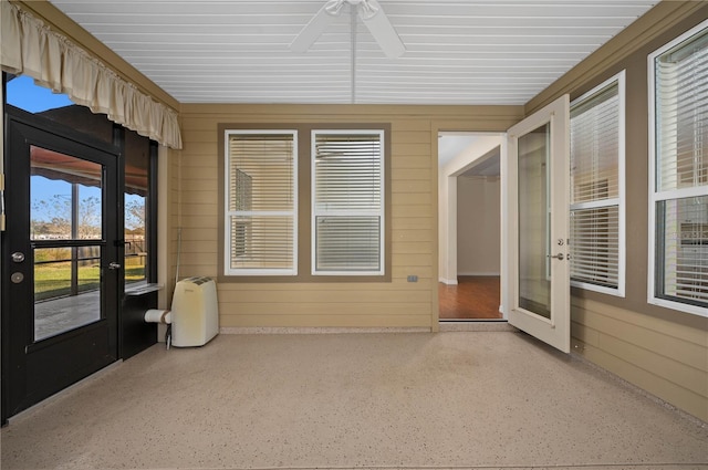 unfurnished sunroom featuring ceiling fan