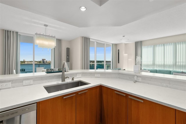 kitchen featuring pendant lighting, dishwasher, a water view, and sink