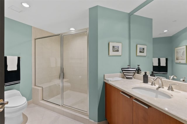 bathroom with tile patterned flooring, vanity, a shower with shower door, and toilet